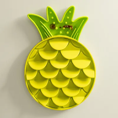Gul slickmatta i form av en ananas med strukturerad yta och matrester, lämplig för aktivering av husdjur.