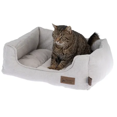 Katzenbett aus grauem Stoff mit gepolsterter Liegefläche, braunem Logoaufnäher 'Modern Living'.