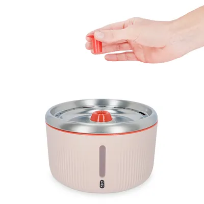 Mână ținând un cartuș de filtru roșu pentru fântână de apă cu suprafață din oțel inoxidabil și indicator de nivel al apei.