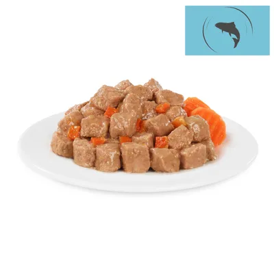 Close-up of wet food pieces with carrots on a white plate. Fish symbol in the top right of the image.