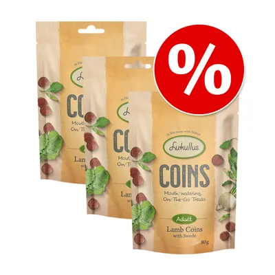 Промо пакет от 3 броя лакомства Lukullus Coins Lamb Coins with Swede, 80 г за възрастни кучета. Видими са зелени листа и червени кръгчета на опаковката. Голям процентен знак.