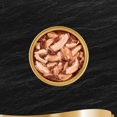 Avoin metallipurkki, jossa näkyy lihaa paloina hyytelössä. Tuotemerkkiä tai tekstiä ei ole näkyvissä.