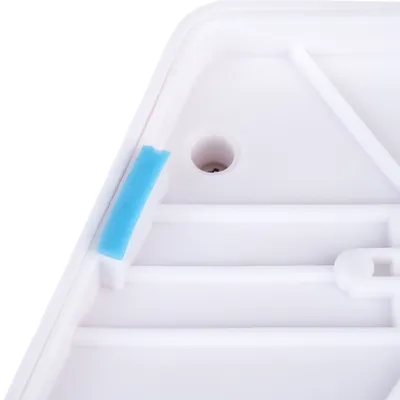 Lähikuva valkoisesta muovipinnasta, jossa on sininen kumipinnoite ja reikä kiinnityselementtejä varten.