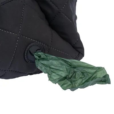 Black bag with dispenser opening, from which a green dog waste bag roll is pulled out.