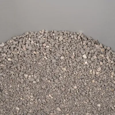 Close-up of grey, granular cat litter with various stone textures.