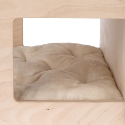 Fa keretes, világos színű macska- vagy kutyaház belseje, benne puha, bézs plüss párnával.