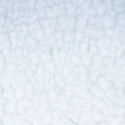 Gros plan sur une surface en tissu polaire blanc, texture bouclée visible.