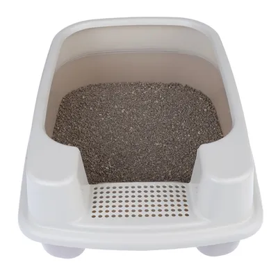 Caja de arena blanca para gatos con arena gris y superficie de rejilla integrada para limpiar las patas.