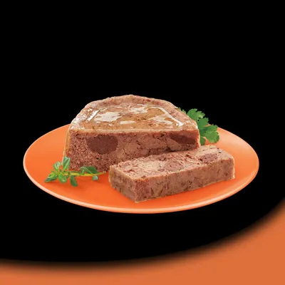 Sliced portion of meat pâté served on an orange plate with fresh herbs, showing product texture and consistency.