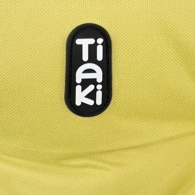 Logo Tiaki na żółtej tkaninie.