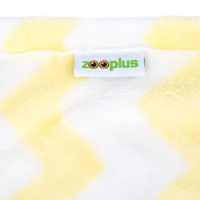 Étiquette zooplus sur tissu à motif rayé jaune et blanc, matière peluche visible.
