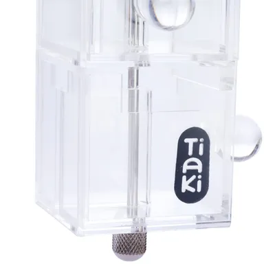 Boîtier transparent en plastique avec le nom de la marque Tiaki visible sur l’étiquette noire et blanche.