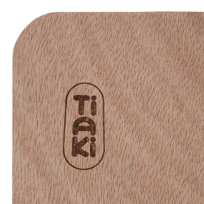 Inscription Tiaki gravée sur une surface en bois clair, coin arrondi visible.