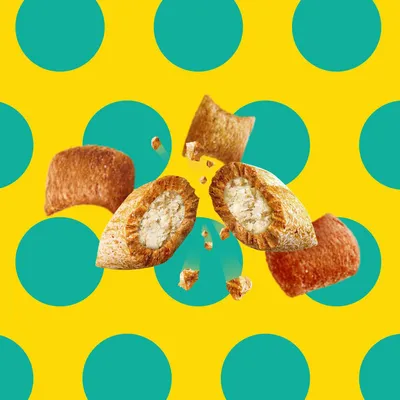 Close-up of crunchy, filled kibble pieces with a visible creamy centre and crumbs, showing product texture and filling.