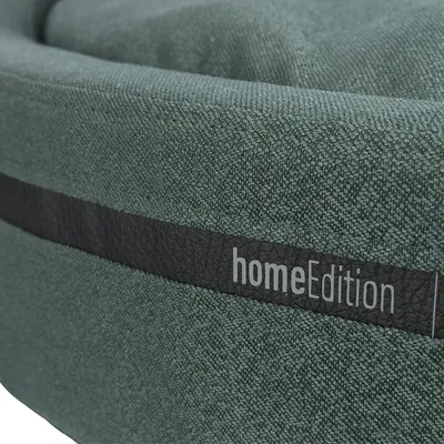 Nahaufnahme eines grünen Stoffmaterials mit schwarzem Band und Schriftzug 'homeEdition'.