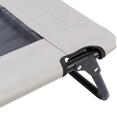 Detailansicht eines erhöhten Liegebetts mit Metallrahmen und beige Stoffbespannung, teilweise Netzmaterial sichtbar.