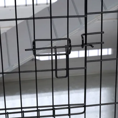 Detailansicht eines schwarzen Metallverschlusses an einem Gitterkäfig.