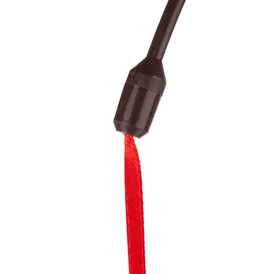 Bâton en plastique noir avec ruban rouge attaché à l’extrémité, visible en gros plan. Aucun texte ou marque apparente.