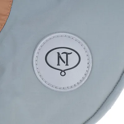 NT inscrit dans un cercle sur une étiquette ronde cousue sur tissu gris, sans autre texte visible.