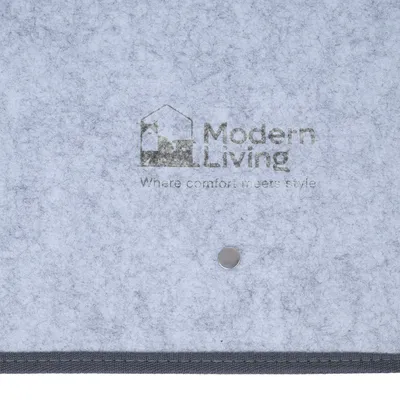 Modern Living Where comfort meets style (texte en anglais) visible sur une surface grise en tissu avec un bouton métallique.