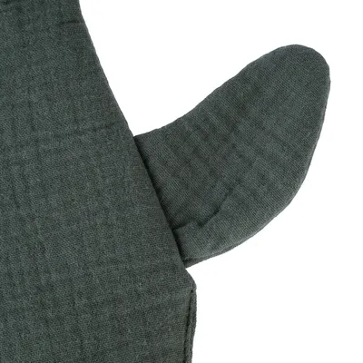 Detailní záběr na tmavě zelený textilní materiál se strukturovaným povrchem, pravděpodobně součást designu produktu.