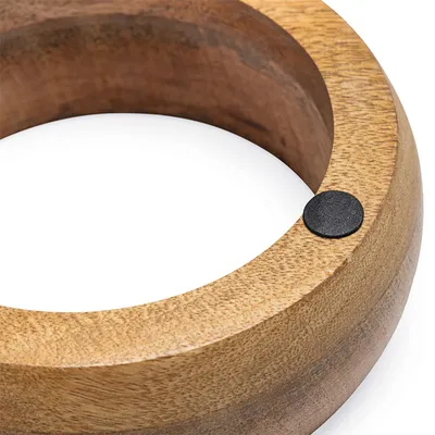 Runder Holzring mit glatter Oberfläche und schwarzem Filzpunkt als Detail.