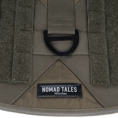 Nomad Tales München. Detailansicht eines braunen Stoffmaterials mit schwarzem Metallring und Klettverschluss.
