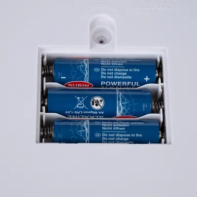 Battery compartment with four inserted Rubin Powerful Alkaline AA batteries, notes: Do not throw into fire, do not recharge, do not open.