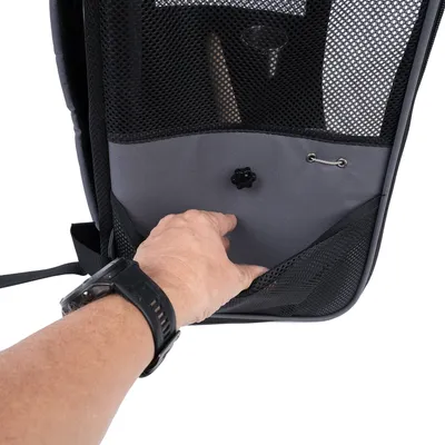 Rugzak met netstof, grijze stoffen tas en ventilatieopening. Hand wijst naar het vak voor extra opbergruimte.
