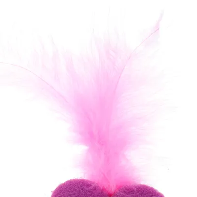 Balle recouverte de tissu violet avec plume rose fixée sur le dessus, visible en gros plan.