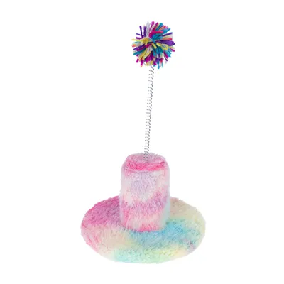 Spielzeug mit buntem Pompon auf einer Feder, befestigt an einem flauschigen Sockel in Regenbogenfarben.