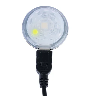 Vue rapprochée d’un accessoire circulaire transparent avec câble noir et connecteur USB visible, aucun texte ou marque apparente.
