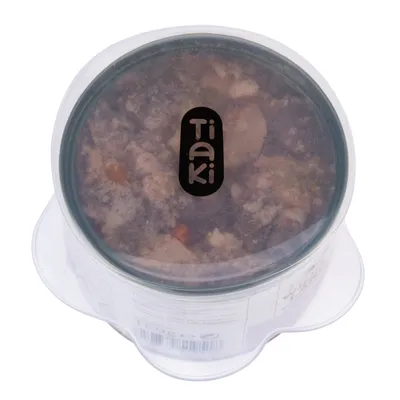 Tiaki wet food in transparent packaging, visible with meat pieces and vegetables.