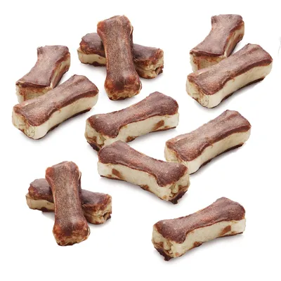 Plusieurs friandises en forme d’os, bicolores marron et beige, disposées sur fond blanc. Aucun emballage ou texte visible.
