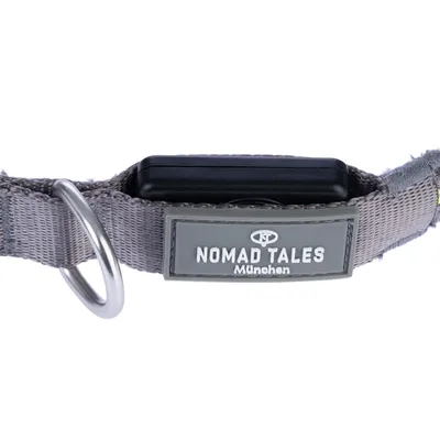 Collier en tissu gris avec boucle métallique et étiquette visible : NOMAD TALES München.