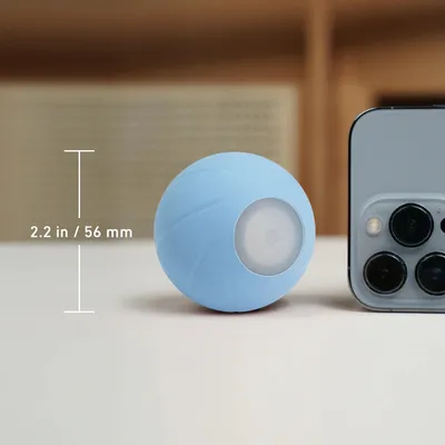 Modrý míček o průměru 2,2 palce (56 mm) vedle smartphonu pro porovnání velikosti.