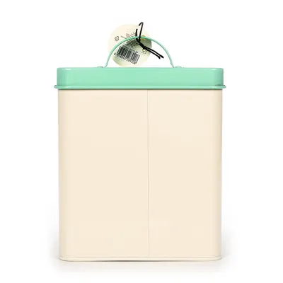 Metalowy pojemnik z miętowozieloną pokrywką i uchwytem, beżowy korpus. Etykieta z kodem kreskowym i informacjami o produkcie widoczna.