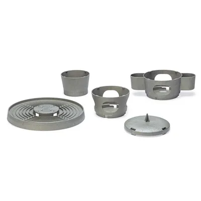 Set de cinco piezas de plástico gris: base redonda con ranuras, dos vasos, inserto con asas y tapa cónica.
