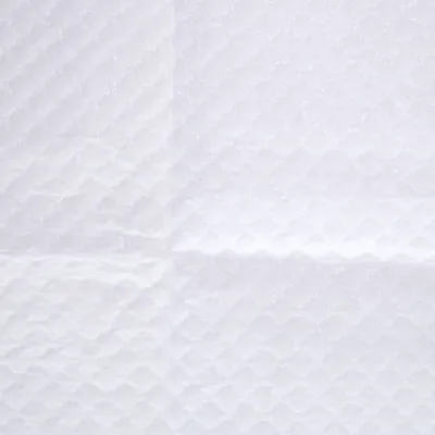 Surface blanche en tissu absorbant à motif losange, vue rapprochée d’une alèse ou d’un tapis hygiénique pour animaux. Aucun texte ni marque visible.
