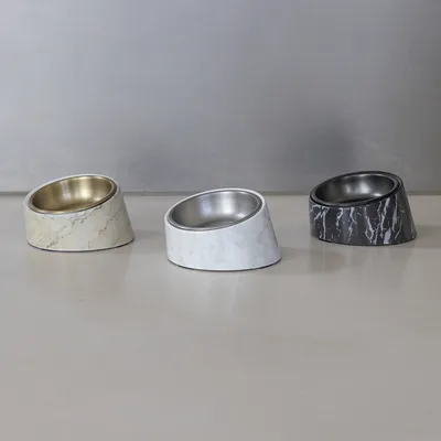 Drei schräg designte Futternäpfe aus Edelstahl mit Marmormuster: beige, weiss und schwarz. Geeignet für stilvolle Fütterung von Haustieren.