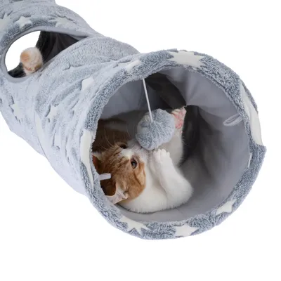 Grauer Spieltunnel mit Sternenmuster, innen eine Katze spielend mit einem hängenden Plüschball. Tunnel hat seitliche Öffnungen.