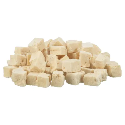 Cubos pequenos de cor bege claro, empilhados, sem embalagem visível. Produto alimentar para animais de estimação apresentado em forma de cubos sólidos.