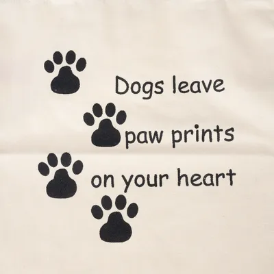 Text: Dogs leave paw prints on your heart, doplněno černými otisky tlapek na béžovém pozadí.