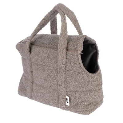 Sac de transport en tissu bouclé beige avec poignées, fermeture éclair sur le dessus et ouverture latérale, étiquette visible sur le devant.