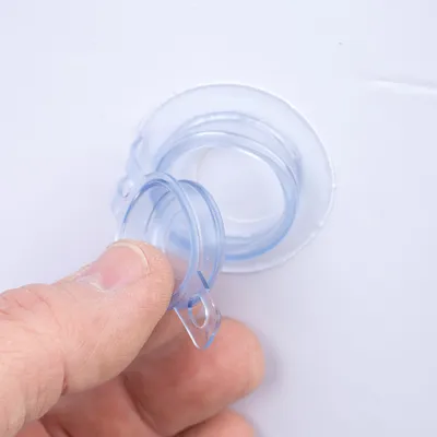 Nærbillede af en transparent plastlukning, der åbnes af en hånd. Viser lukkemekanismens funktion.