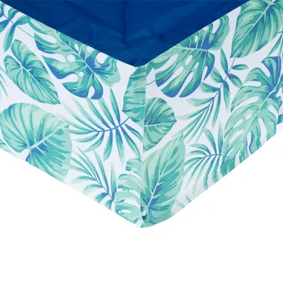Widok narożny prostokątnego legowiska z niebieskim wnętrzem i tropikalnym wzorem liści na zewnątrz.
