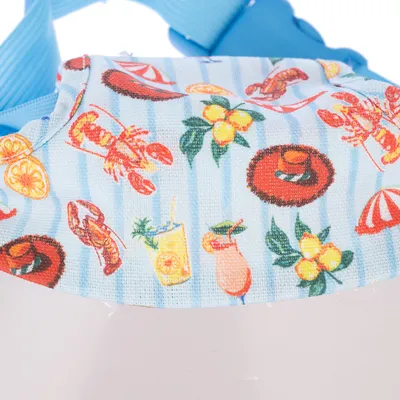 Jasnoniebieski materiał z kolorowym wzorem homarów, owoców, napojów i motywów letnich. Widoczna część produktu z niebieskimi paskami.