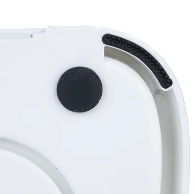 Close-up of a white plastic housing with a black round magnet and non-slip rubber coating.