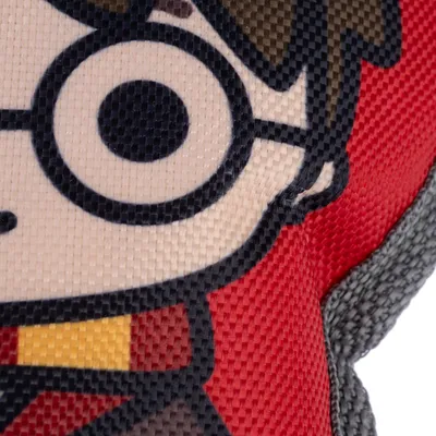 Detaljevisning af legetøj med Harry Potter-motiv, rød baggrund og grå accenter.