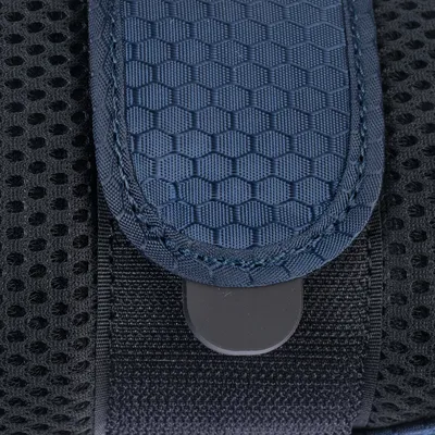 Gros plan sur une sangle en tissu bleu à motif hexagonal et maille noire, avec un fermoir en plastique visible. Matériaux : tissu et plastique.